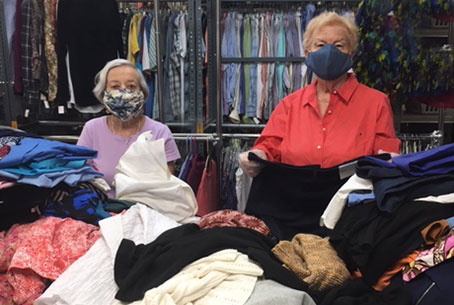 Two Ladies in warehouse sorting clothes
