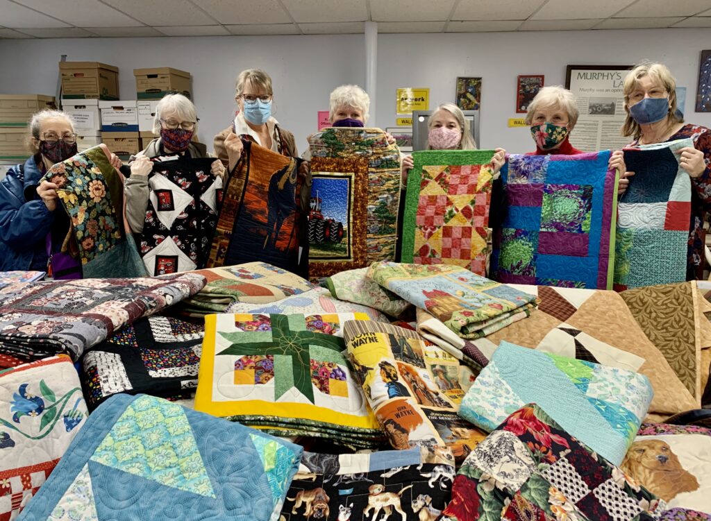 Members of Lynden's Pieceable Quilters Guild present quilts to ALB members