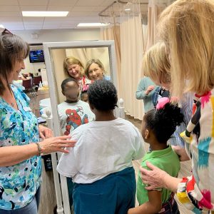 Two students admire their new clothes while Assistance League of Birmingham assist them during Operation School Bell.