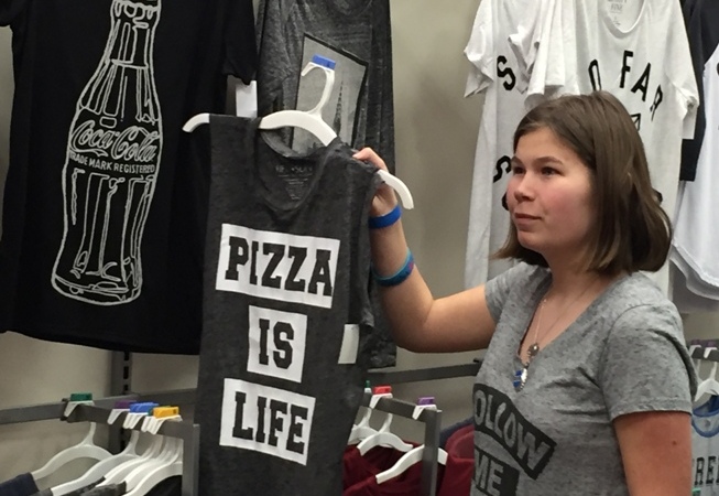 Teen choosing a t-shirt at Teen Retail event