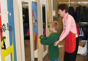 Boy looking into the mirror to see how his new jeans fit at Operation School Bell