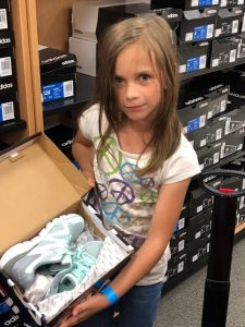 Girl shoe shopping at Canyon County Branch's first Operation School Bell event.