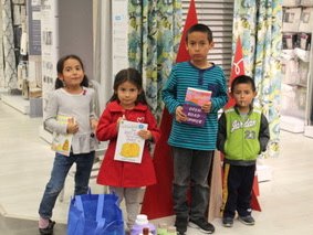 Cute kids at Operation School Bell shopping event showing off their books and clothing