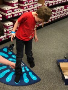 Boy having his foot sized at an Operation School Bell event