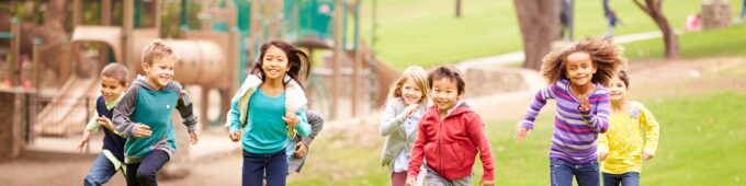 Group Of Young Children Running In Park