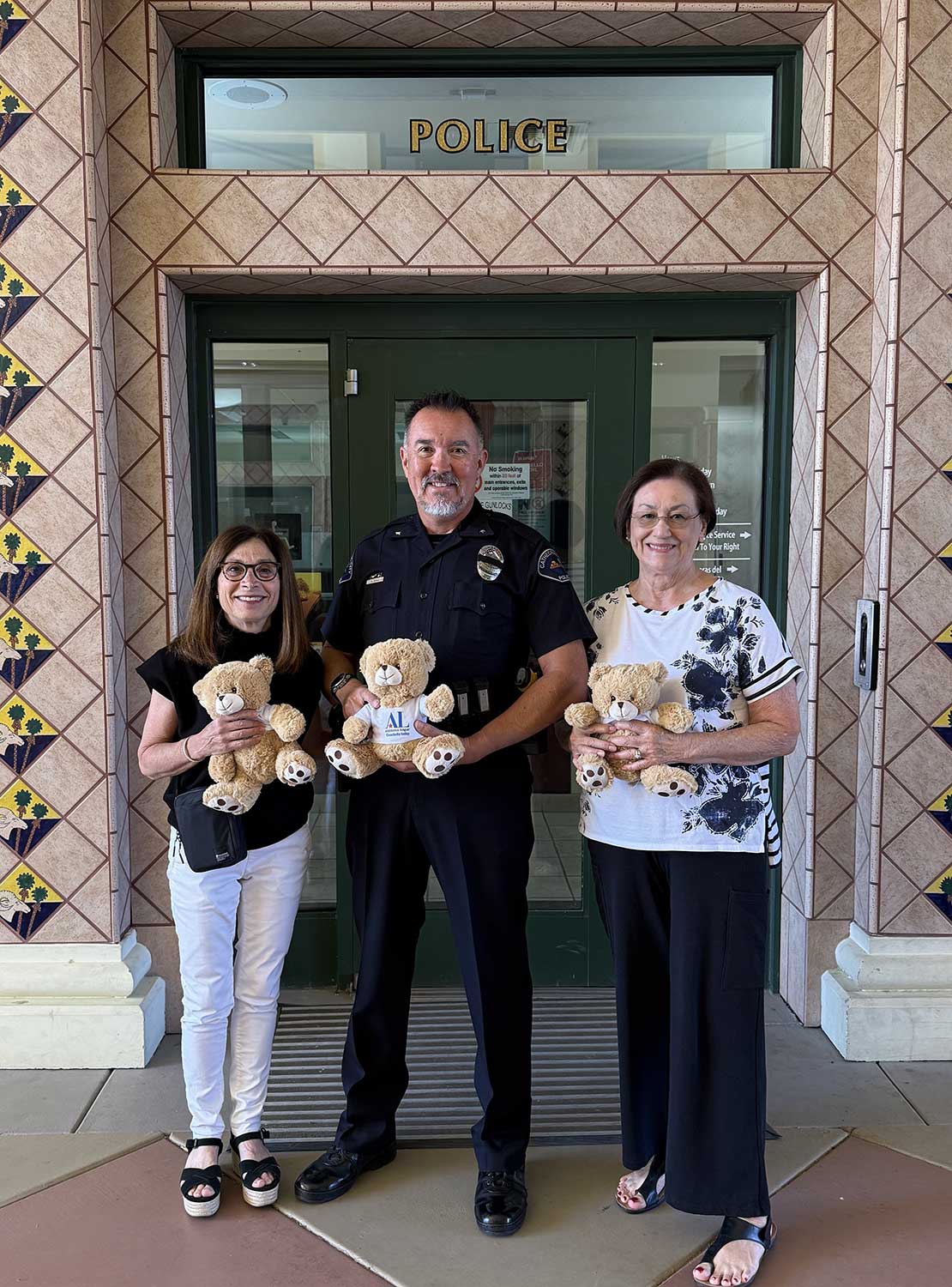 Members Fredi Bensdorf and Delia Masse presents teddy bears teddy bears to the Cathedral City Police Department.