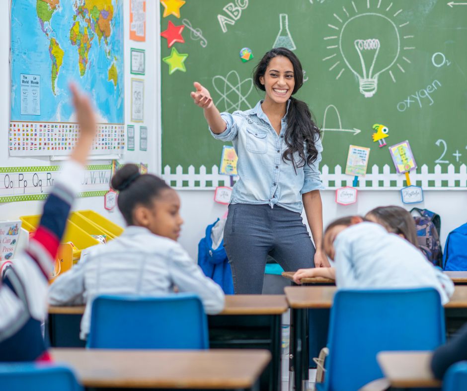 Teacher in Classroom with Chalkboard and map