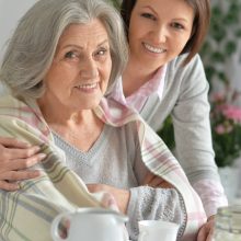 Portrait of senior woman with daughter drinking tea at home