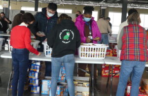 Volunteers assisting with packing food at ALNV Weekend Food for Kids event