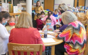 A group of volunteers from ALNV speaking with children