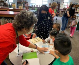 An ALNV member helps a child during the book fair