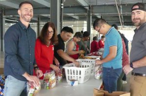 Volunteers in a packing line at the Weekend Food for Kids packing event