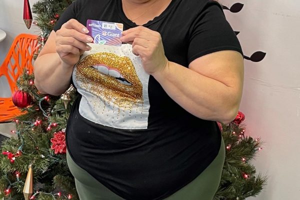 A person holding a grocery gift card from ALNV