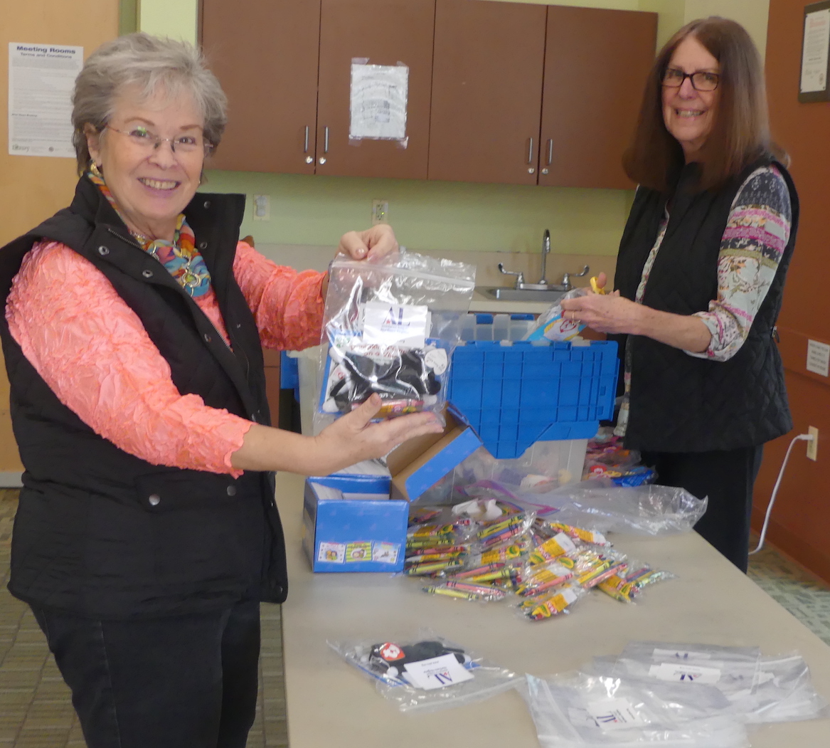 Two ALNV members show the bags that were prepared as part of their Bedtime Hugs event
