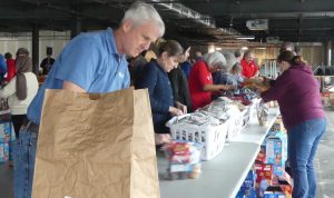 Volunteers pack bags for kids at the Weekend Food for Kids event