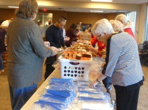 Volunteers help to pack clothing items for children