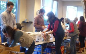 A full packing line of volunteers helping to create individual donation packages