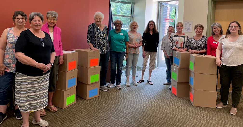 ALVN members stand proudly next to boxes of books.