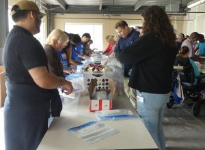 ALNV and volunteers from various local companies help pack food for kids