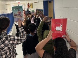Students holding up their selection of books