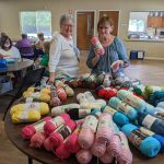 Lynda and Sheila with table of yarn