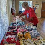 Phyllis with a table of layettes