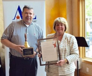 Presenting the award to Mike Harman is Barbara Slater, Operation School Bell Chair and Past President of Assistance League of Salt Lake City