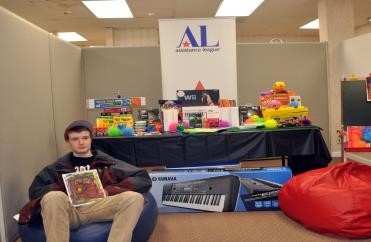 A member of Charlie’s Gift Center Teen Club poses with items received via Assistance League’s Project Stepping Stone philanthropy.
