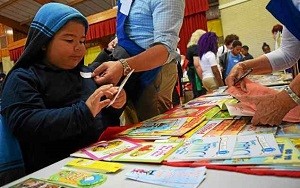 Devin Cantley, six, picks out a new book from those donated during the Assistance League of Southeast Michigan’s book drive, during Operation School Bell at Alcott Elementary School on Thursday, Oct. 13, 2016. Photo By Natalie Broda