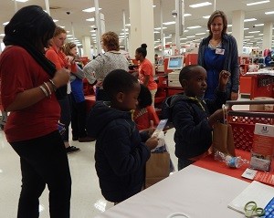 Two elementary students take a goodie bag while a teacher watches after shopping for school clothes at North Hills Target in Raleigh Tuesday night. 