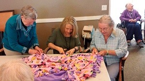 From left, Aegis of Redmond resident Karen Hammond, Tammy Hervey (life enrichment director at Aegis of Redmond) and resident Phyllis Bordner make blankets for children and families in need. Courtesy photo