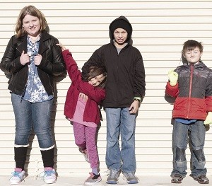 Zoey, from left, Ariel and her brother, Eved, and Ethan show the new shoes, jackets, gloves and other clothes they received through Operation School Bell in Snohomish County