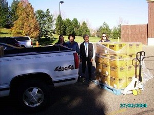 Wal-Mart employees Tausha Guerane, left, and Amiee Shaw assist Assistance League of Greeley members Missi Harrison and Jan Krause with loading the Warm Up Weld blankets for distribution.