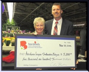 Bordine's President Calvin Bordine presents a check for $5,100 to Marjorie DiLiddo, president of Assistance League of Southeastern Michigan.