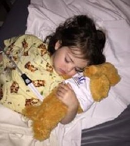 A young girl hugs Ouch, the bear she received from the Assistance League of Temecula Valley