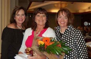 Rick Racker Woman of the Year: Tammy Newland (center), The Rick Racker 2017 Woman of the Year, is presented with a congratulatory bouquet from the event chair Nancy Smith, on left, and from Rick Racker Chair Sheryl Pearl, on the right.