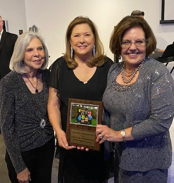 A group of women holding a framed award