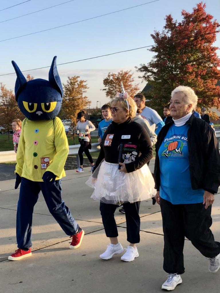 A group of people walking with a person in a costume